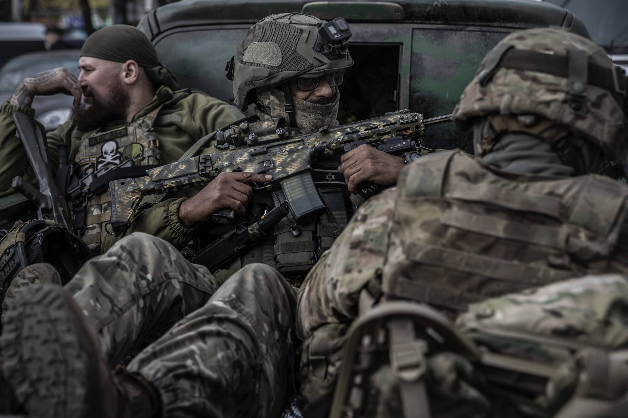 Members of the Ukrainian Armed Forces ride in the back of a vehicle in the southern Ukrainian city of Kherson on Wednesday. | Finbarr O'Reilly / The New York Times