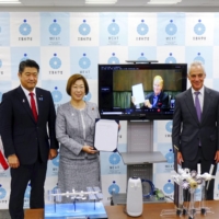 Keiko Nagaoka (second from left), minister of education, culture, sports, science and technology, and NASA Administrator Bill Nelson (on screen) pose for photos on the occasion of the signing of an agreement on the Gateway space program in Tokyo on Friday. | KYODO