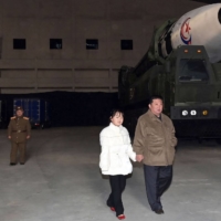 North Korean leader Kim Jong Un (right) with his daughter as he inspects a new intercontinental ballistic missile, the Hwasong Gun 17, at Pyongyang International Airport in this photo released Saturday. | KCNA / KNS / VIA AFP-JIJI 
