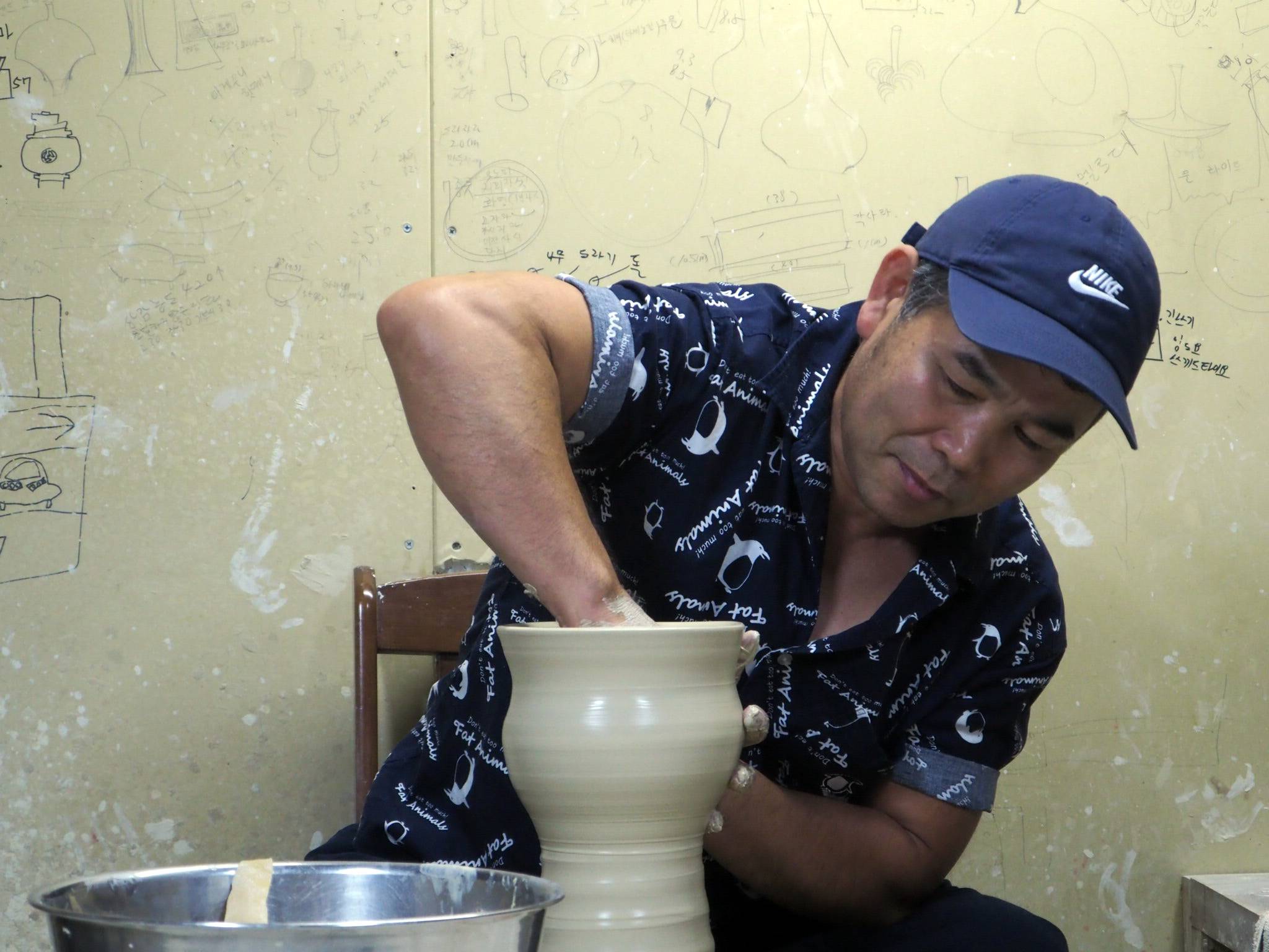 Ceramicist Kim Kyungduk demonstrates his throwing technique at his studio in Nanto, Toyama Prefecture. | MIO YAMADA 