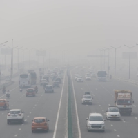 Traffic moves along a highway shrouded in heavy smog in New Delhi. | REUTERS
