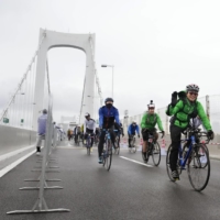 Cyclists ride across Rainbow Bridge in Tokyo on Wednesday during a bicycle event. | KYODO