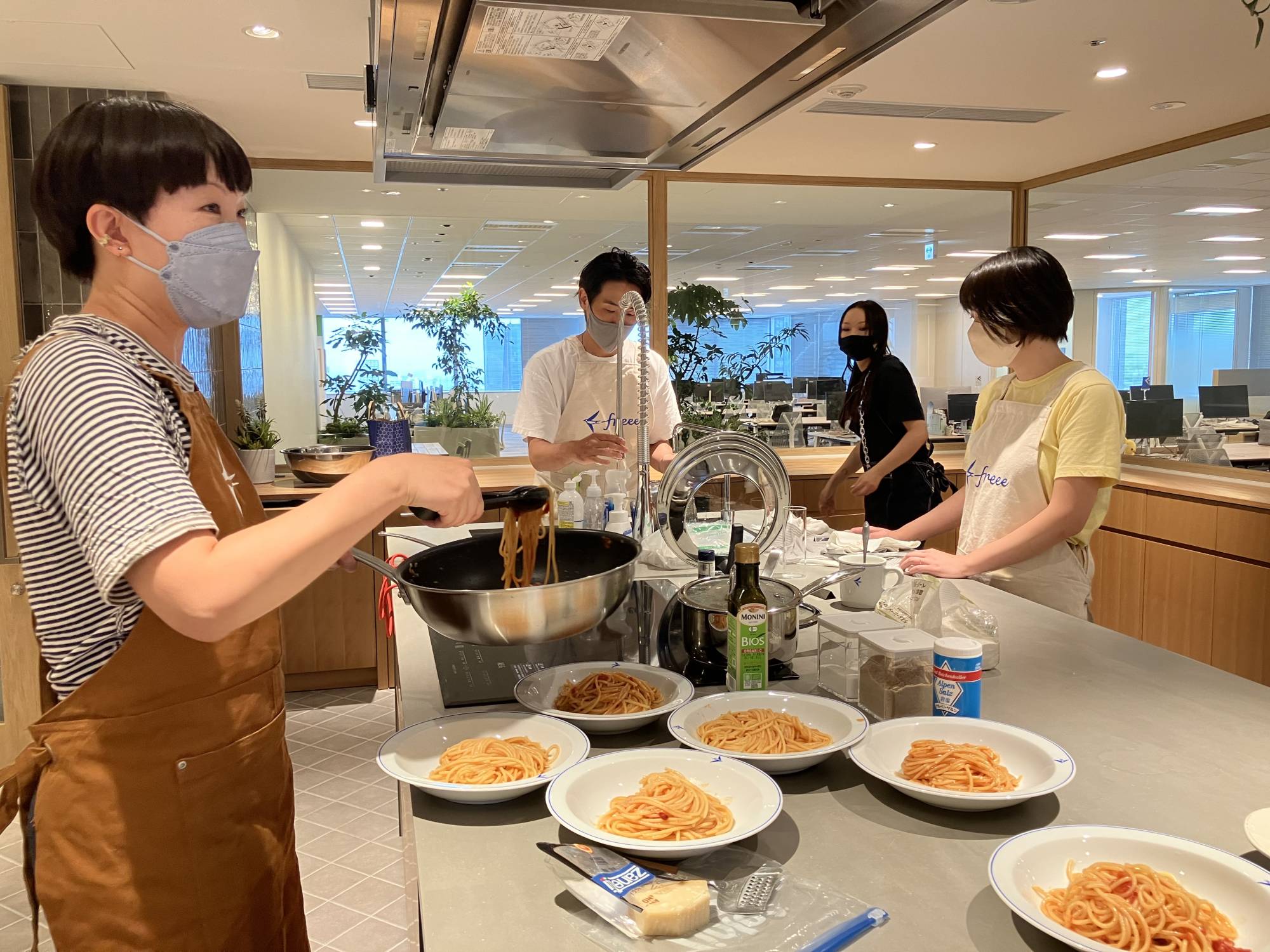 Employees at Tokyo-based tech firm Freee gather in a kitchen and cook together at its new office in September. | KAZUAKI NAGATA