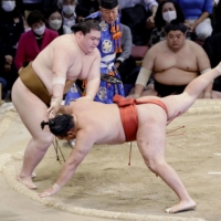 Oho (left) defeats Hoshoryu on the 12th day of the Kyushu Grand Sumo Tournament on Thursday. | KYODO