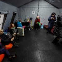 Local residents inside a so-called invincibility center after critical civil infrastructure was hit by Russian missile attacks in Kyiv on Thursday. | REUTERS