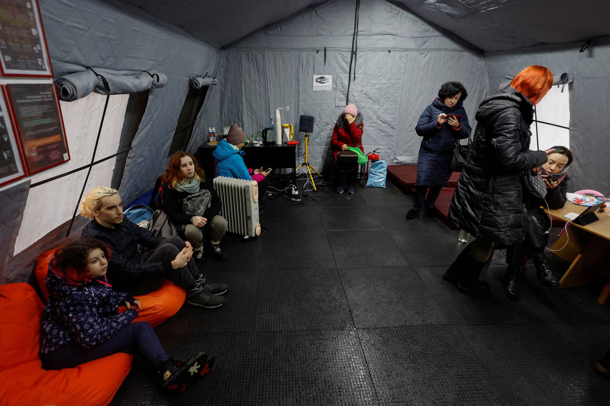 Local residents inside a so-called invincibility center after critical civil infrastructure was hit by Russian missile attacks in Kyiv on Thursday. | REUTERS