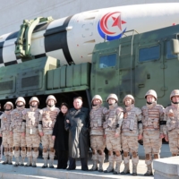 North Korean leader Kim Jong Un and his daughter pose with soldiers in front of a new intercontinental ballistic missile in this undated picture released Sunday.  | KCNA / KNS / VIA AFP-JIJI