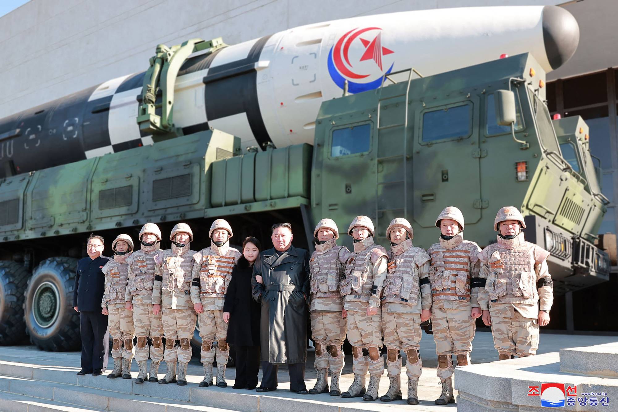 North Korean leader Kim Jong Un and his daughter pose with soldiers in front of a new intercontinental ballistic missile in this undated picture released Sunday. | KCNA / KNS / VIA AFP-JIJI