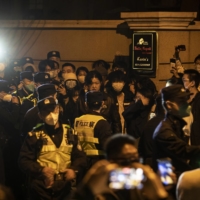 Police officers block Urumqi Road, where protests had taken place the night before, in Urumqi, China, on Sunday. Many people suspected that a COVID-19 lockdown had hampered rescue efforts or trapped victims inside their homes during a deadly fire over the weekend, and though officials denied that had happened, angry comments flooded social media and residents took to the streets in the city where the fire erupted.  | THE NEW YORK TIMES