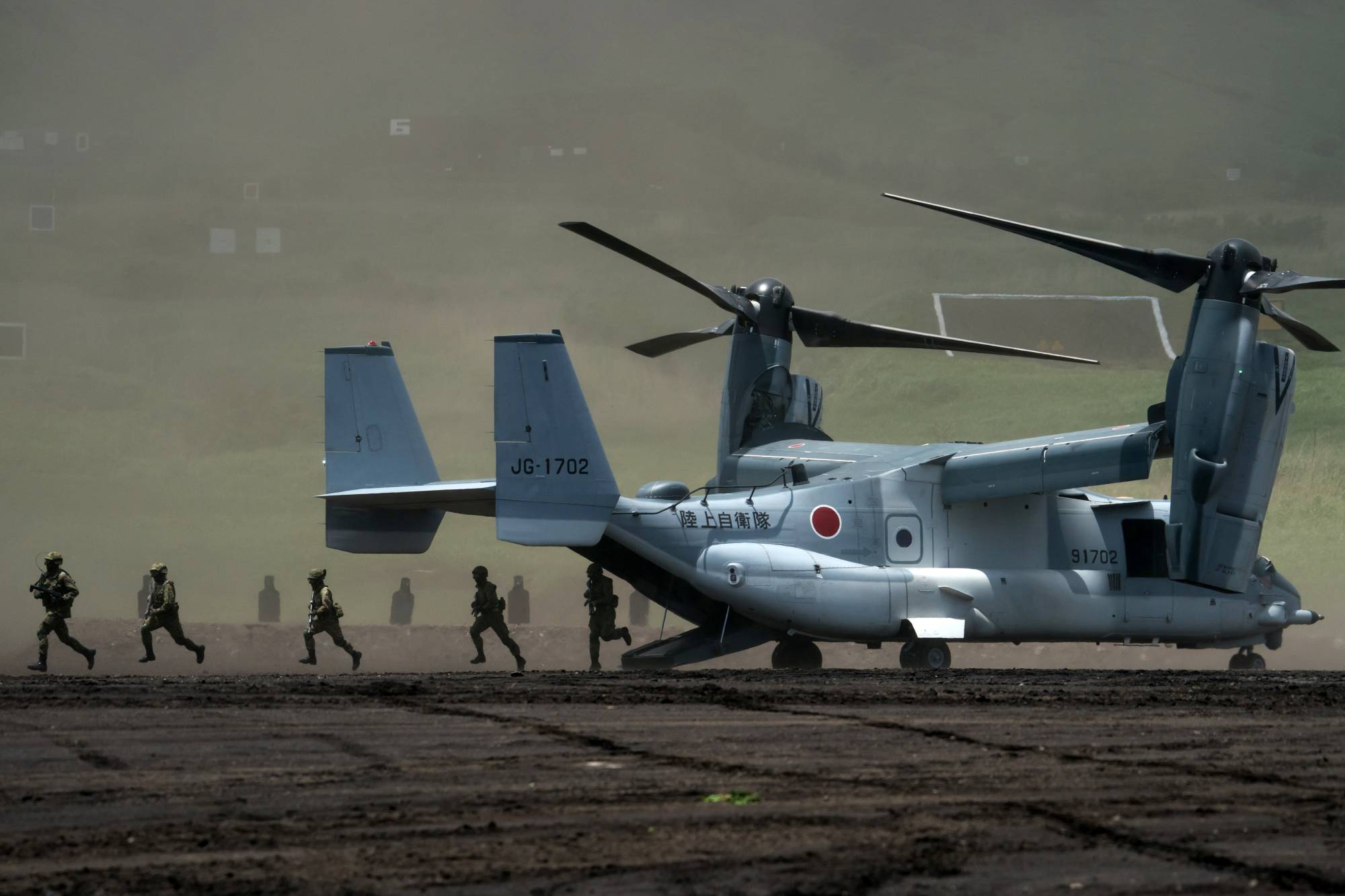 Ground Self-Defense Force members disembark from a V-22 Osprey aircraft during annual live-fire exercise at the East Fuji Maneuver Area, in Gotemba, Shizuoka Prefecture, in May. | POOL / VIA REUTERS