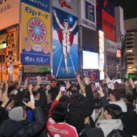 Soccer fans celebrate Friday in Osaka\'s Dotonbori district after Japan’s win over Spain in the World Cup. | KYODO