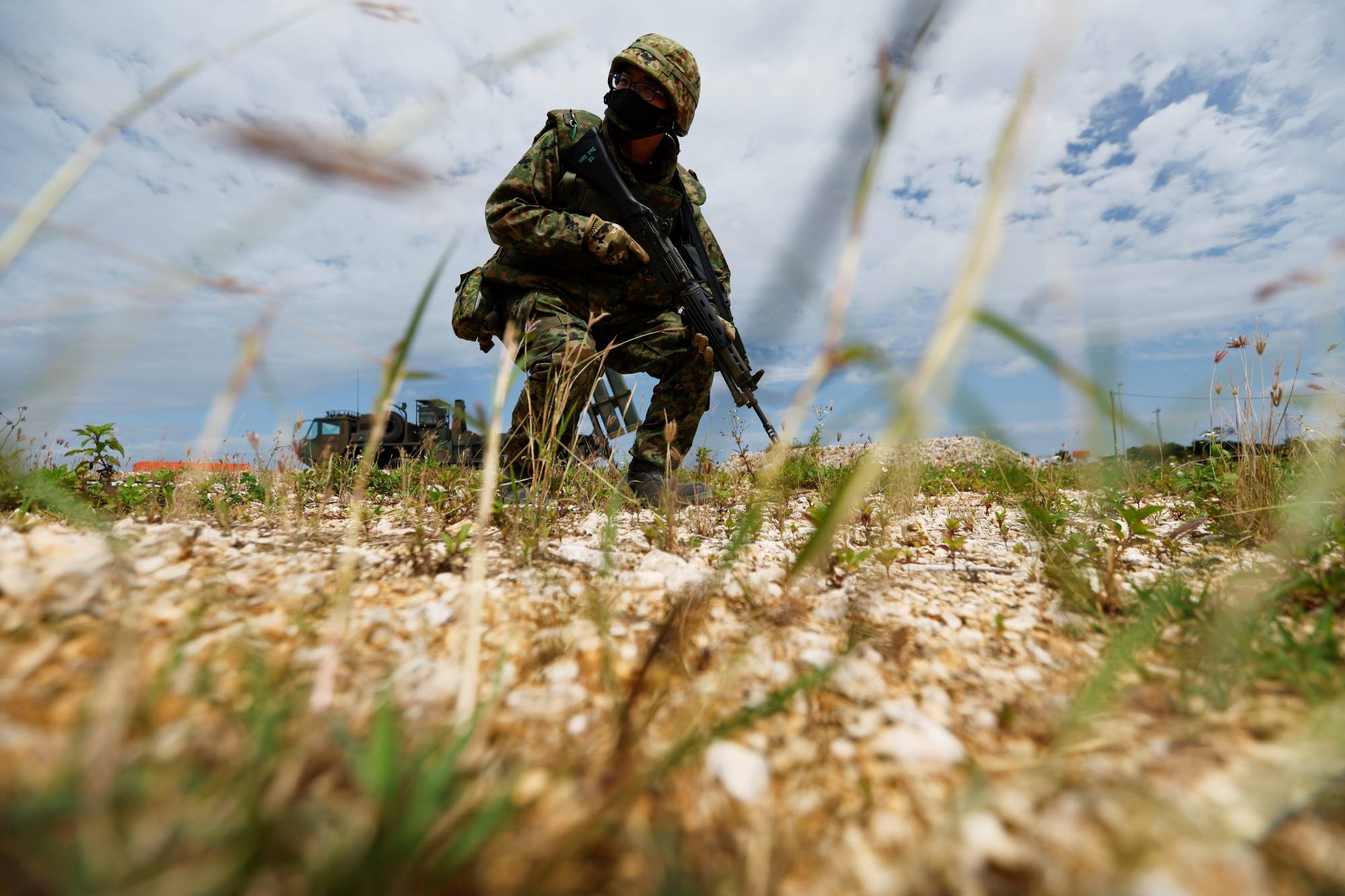 A Ground Self-Defense Force member conducts a military drill next to an anti-ship missiles unit at the GSDF camp on Miyako Island in Okinawa Prefecture on April 21. | REUTERS