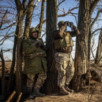 Ukrainian servicemen observe Russian positions on the front line in eastern Ukraine on Saturday. | AFP-JIJI