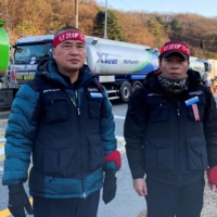 Striking South Korean unionized tank drivers Lee Geum-sang and Ham Sang-jun in front of a major oil storage facility in Seongnam, south of Seoul, on Thursday | REUTERS