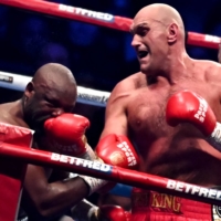 Tyson Fury punches Derek Chisora during their WBC heavyweight title match in London on Saturday. | AFP-JIJI