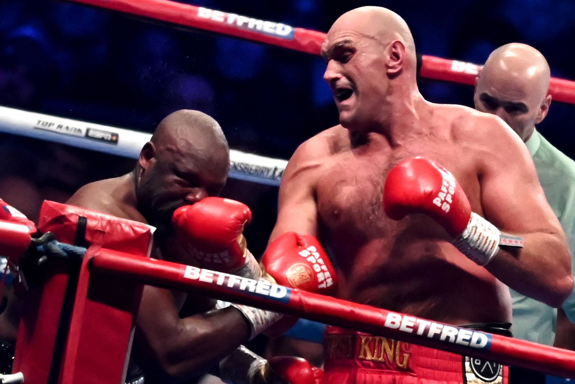 Tyson Fury punches Derek Chisora during their WBC heavyweight title match in London on Saturday. | AFP-JIJI