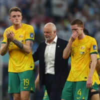 Australia coach Graham Arnold (center), Harry Souttar and Kye Rowles look dejected after Australia was defeated by Argentina and eliminated from the World Cup in Qatar on Saturday. | REUTERS