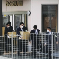 Shizuoka Prefectural Police investigators take out boxes of documents after raiding Sakura Hoikuen nursery school in Susono, Shizuoka Prefecture, on Sunday. | KYODO