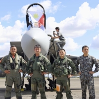 Philippine Air Force (left and second from left) and Japanese Air Self-Defense Force personnel mark the historic arrival of two ASDF F-15 fighter jets with a photo at Clark Air Base in Mabalacat, north of Manila, on Tuesday. | KYODO
