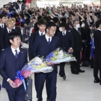 The Japan national soccer team is greeted by a crowd of fans on its return from the 2022 FIFA World Cup in Qatar, at Narita Airport on Wedesnday. | KYODO