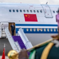 Xi waves upon arrival at King Khalid International Airport on Wednesday. | AFP PHOTO / HO / SPA