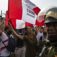 Demonstrators celebrate in front a police station where President Pedro Castillo was being detained in Lima on Wednesday. Castillo was ousted from office after he tried to dissolve Congress and install an emergency government to rule by decree, a stunning move that political leaders across the spectrum were quick to denounce as a coup attempt. | MARCO GARRO / THE NEW YORK TIMES