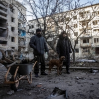 Local residents stand in the yard of their destroyed apartment building in Bakhmut, in the Donetsk region of Ukraine on Wednesday. | REUTERS