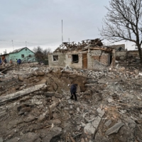 A local resident inspects a crater left by a Russian military strike in the village of Kupriianivka, Zaporizhzhia region, Ukraine, on Wednesday. | REUTERS