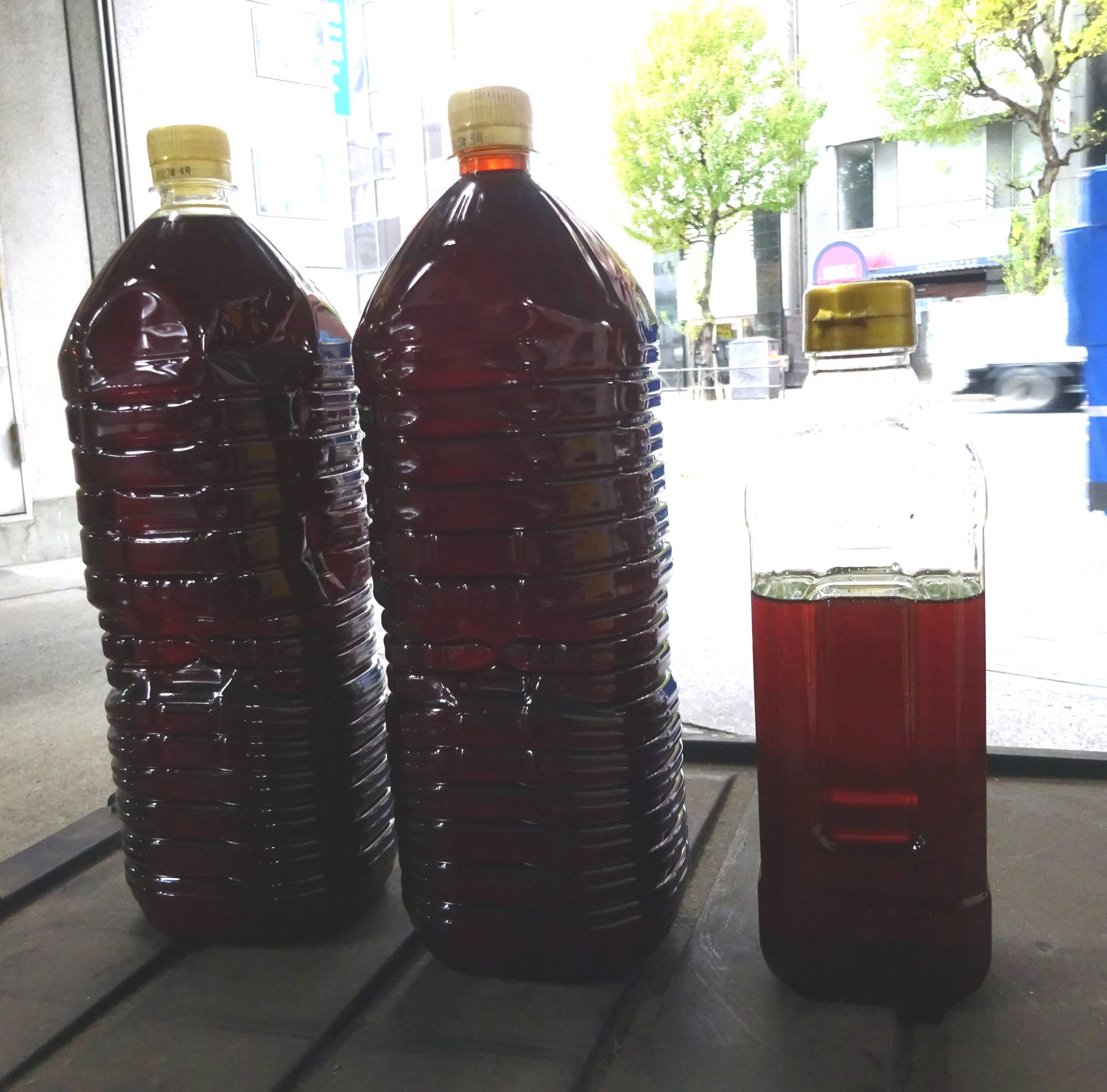 Plastic bottles containing waste cooking oil. If waste cooking oil is shipped overseas, it will become difficult to supply sustainable aviation fuel in Japan, which could lead to some eco-friendly foreign airlines avoiding flying into the country. | CHUGOKU SHIMBUN