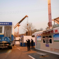 Staff members remove a facility used to check for COVID-19 test results at the entrance to a highway in Taiyuan, in China\'s central Shanxi province, on Friday. | CNS / VIA AFP-JIJI    