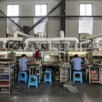 Workers on an assembly line at a Shanghai Electronic Components facility in Ruili, Yunnan province, China, in August | BLOOMBERG 