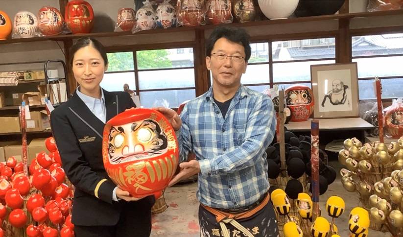 A JR East employee poses with a craftsman at a <i>daruma</i> (lucky doll) workshop during an online tour for Singapore in September. | EAST JAPAN RAILWAY COMPANY