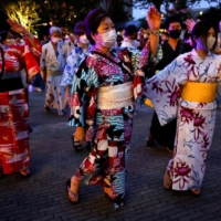 Revelers take part in a Bon Odori festival in Tokyo\'s Nakano Ward on Aug. 6. Even as Japan eased COVID-19 measures and avoided the states of emergency of years past, many still took a cautious approach to daily life and public events. | REUTERS