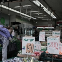 A customer at a vegetable store in Tokyo on Oct. 19. Amid a weakening yen and global supply chains issues, Japan got its first proper taste of inflation in decades, crimping household budgets. | BLOOMBERG