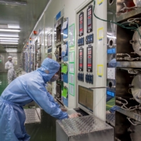 Employees work at a production line manufacturing chips inside a factory of an electronics company in Chizhou, China, in March 2018. | REUTERS