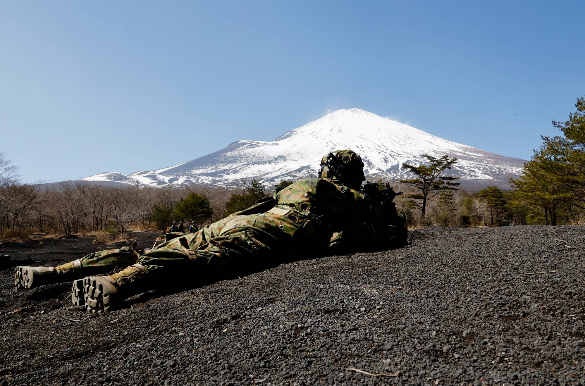 A member of the Self-Defense Force’s Amphibious Rapid Deployment Brigade takes a position during joint airborne landing exercises with the U.S.Marine Corps in Gotemba, Shizuoka Prefecture, in March. | REUTERS