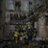Rescuers work at the site of a residential building damaged by a Russian missile in Kryvyi Rih, Ukraine, on Friday. | REUTERS