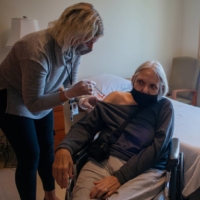 A resident at a nursing care facility in New York receives the new bivalent booster shot in September. | ANDREW SENG / THE NEW YORK TIMES
