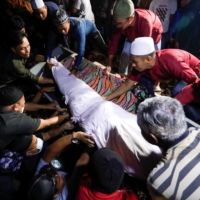 Family and friends carry the body of someone who died in a landslide in Batang Kali in Kuala Lumpur on Saturday. | REUTERS