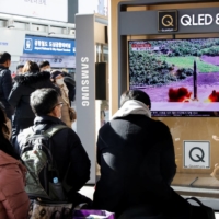 People watch a TV news report on North Korea\'s ballistic missile launches, in Seoul on Sunday. | REUTERS