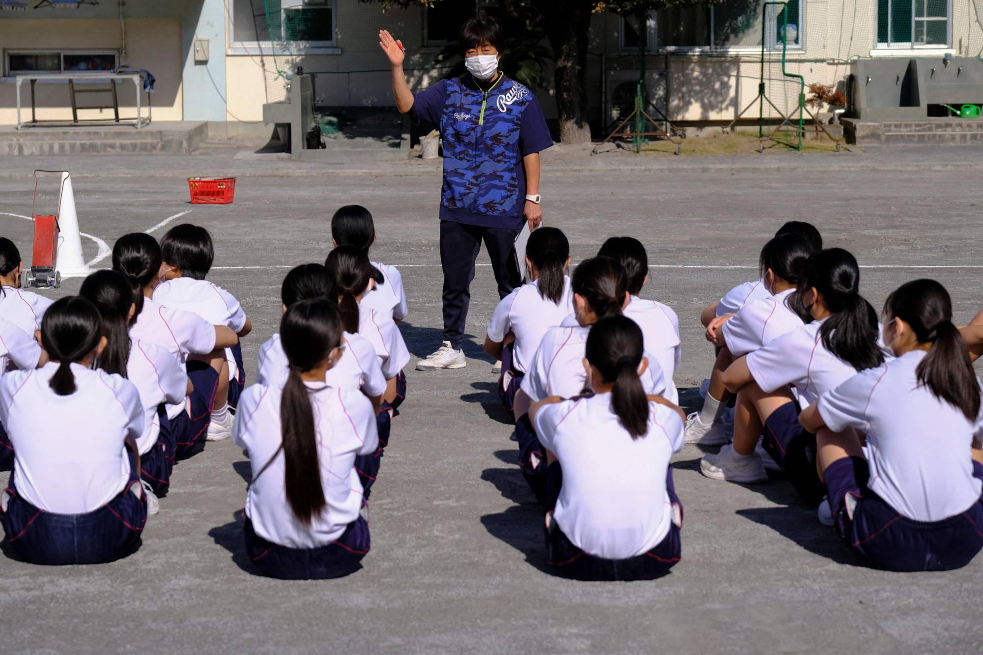 Masako Shimonomura, a junior high school physical education teacher, speaks to students during a class at her school in Tokyo. Shimonomura says it can feel hard to take a proper break during her work day. | AFP-JIJI