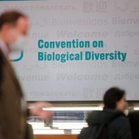 People walk in front of the convention sign at the U.N. COP15 biodiversity conference in Montreal on Saturday. | AFP-JIJI