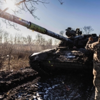 Ukrainian soldiers move a T-72 tank forward as they attempt to repair a track in the Donetsk region of eastern Ukraine on Monday.  | AFP-JIJI