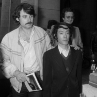 Issei Sagawa (right) is escorted by French plainclothes police as he leaves the Paris Police Prefecture Headquarters after questioning in June 1981. | AFP-JIJI
