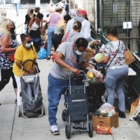Residents receive supplies from a food bank in New York in July. | JOHN SMITH / VIEWPRESS