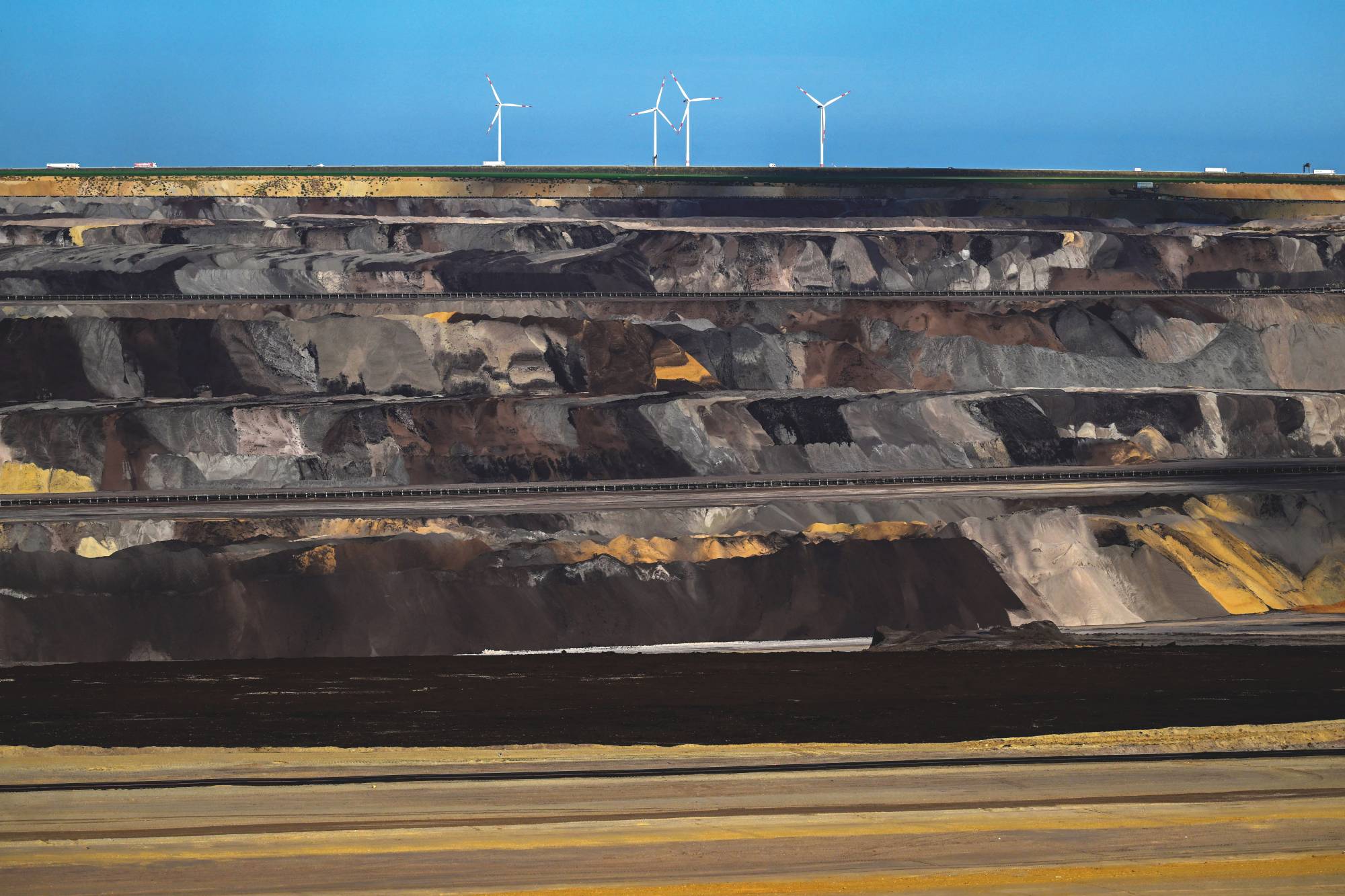 Wind turbines stand above an open-cast lignite mine in Germany. | INA FASSBENDER / AFP / via Getty Images