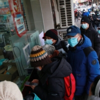 People line up to buy medicine at a pharmacy in Nanjing on Tuesday. | AFP-JIJI