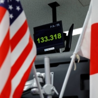 A monitor shows the yen exchange rate against the U.S. dollar at a foreign exchange dealer in Tokyo on Tuesday, when the Bank of Japan unexpectedly tweaked its policy. | REUTERS