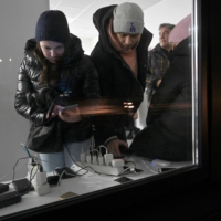 People charge their phones in a post office during blackout hours in Kyiv on Tuesday. | AFP-JIJI