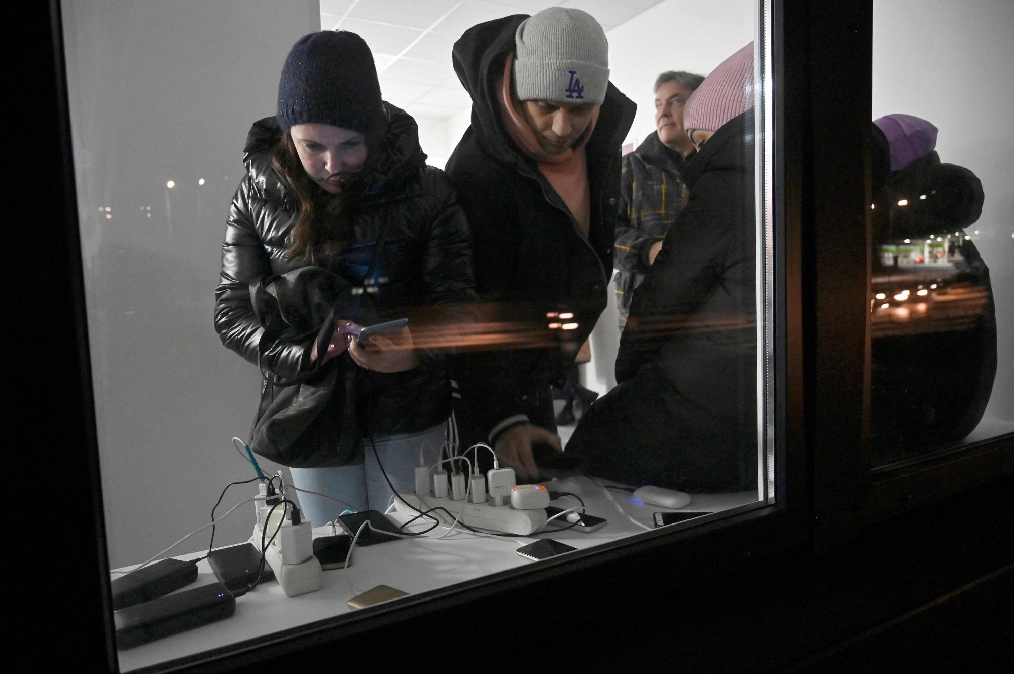 People charge their phones in a post office during blackout hours in Kyiv on Tuesday. | AFP-JIJI